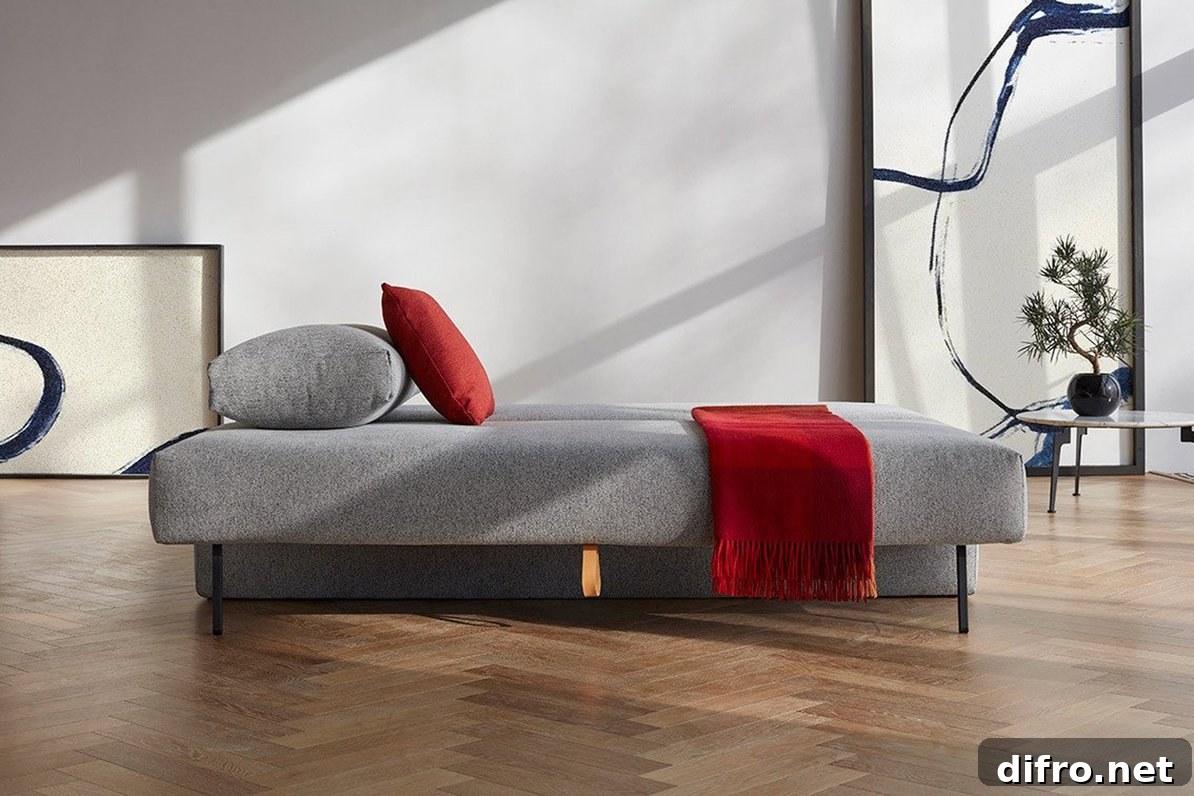 Grey sofa bed converted into bed with bedding