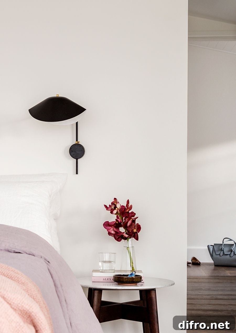 Decorating the small space next to the bed with a tiny side table and sconce light