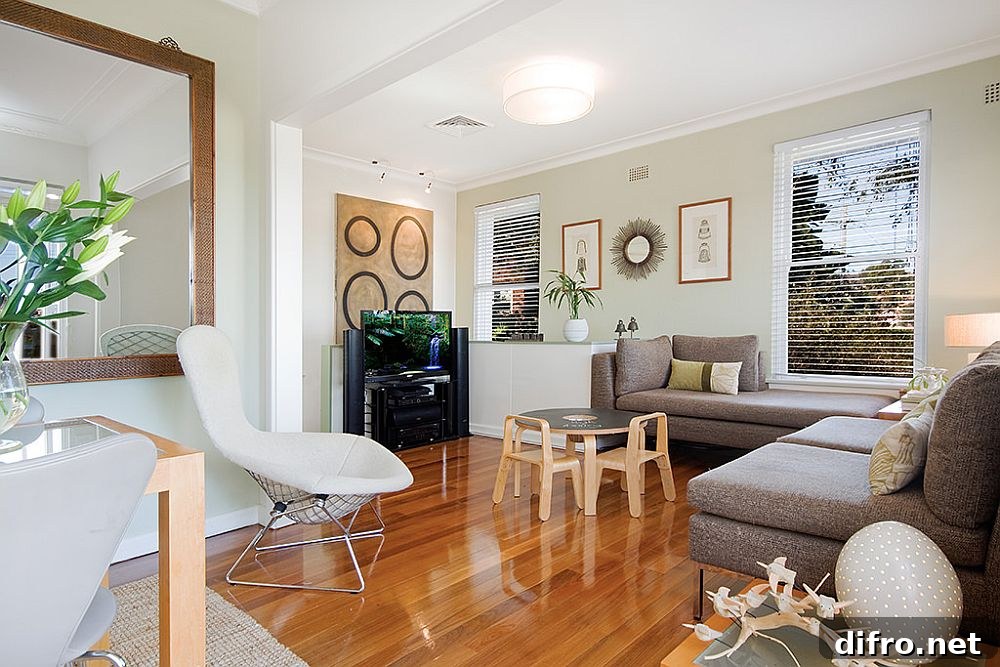 Family room with white walls, wooden floor and dark gray sofas