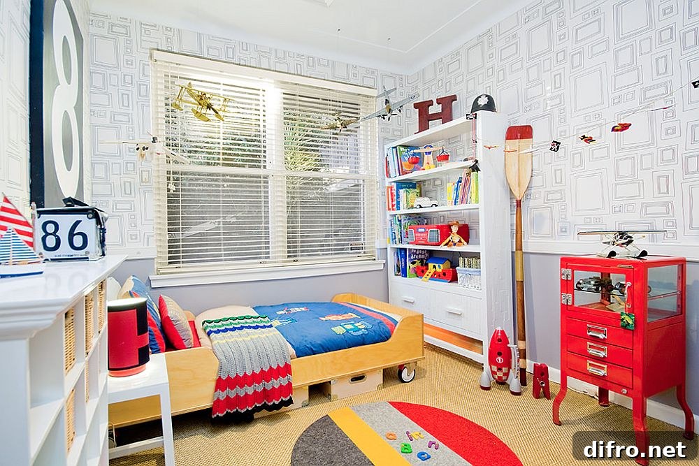 Kids' bedroom in white with a bed on wheels and bold red accents