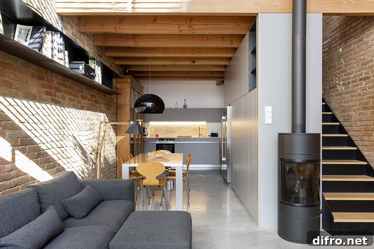 Interior view of Casa EP15340 with gray couch and kitchen cabinets blending with exposed brick walls