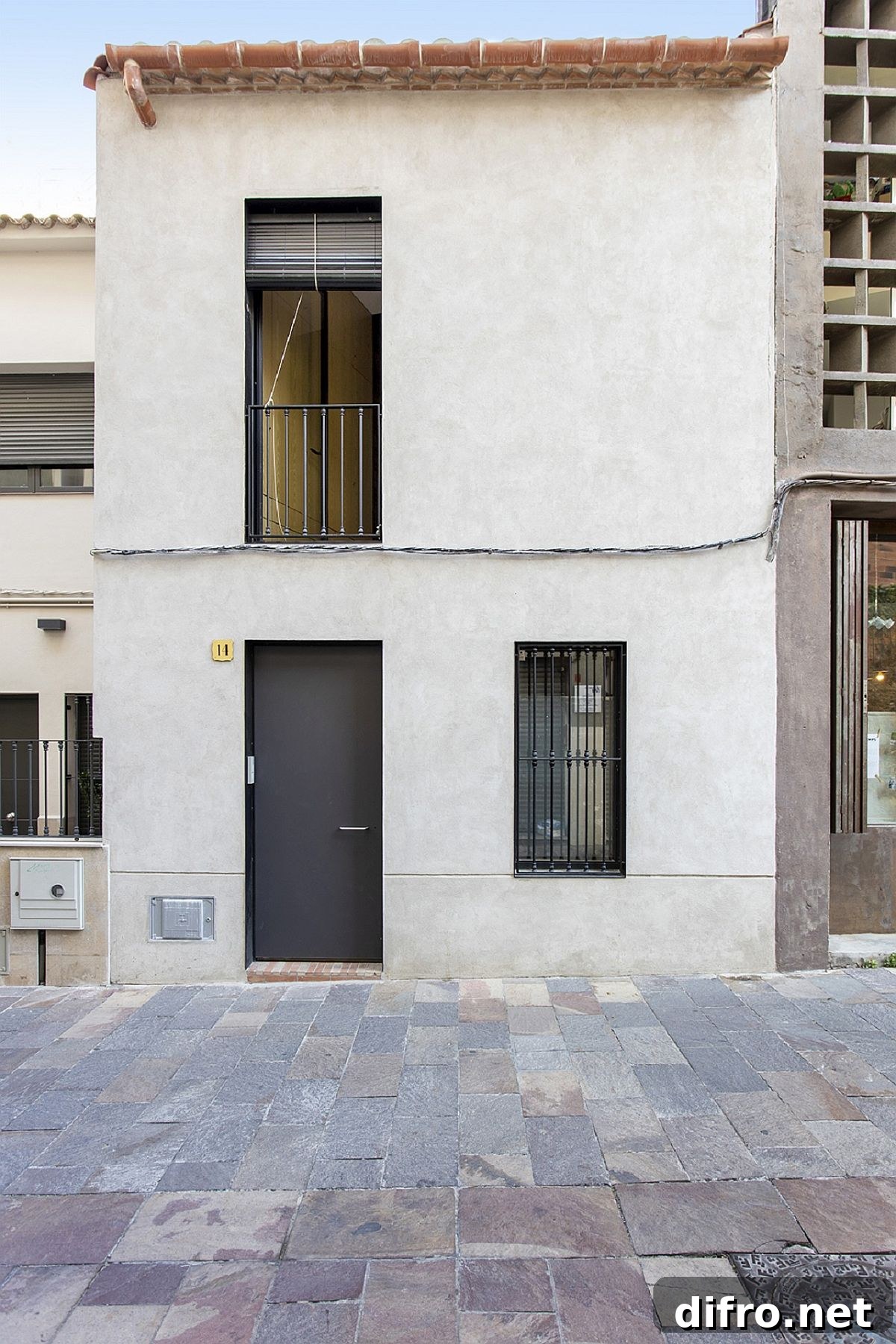Street facade of Casa EP15340 in Sant Cugat del Vallès with black doors and preserved character