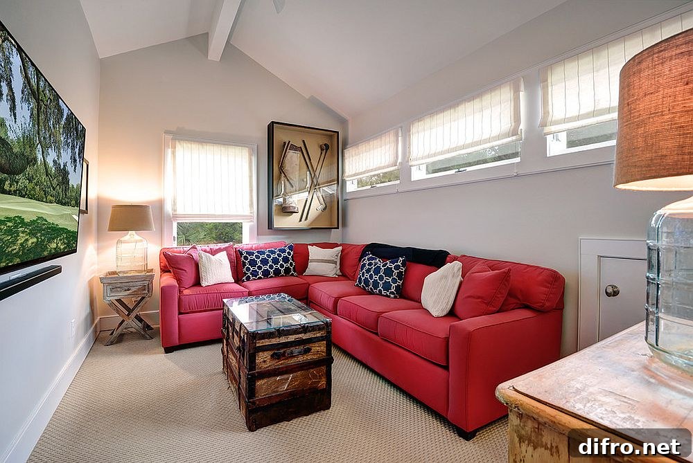 Bright red sectional maximizes sitting space in this tiny media room that is cheerful.