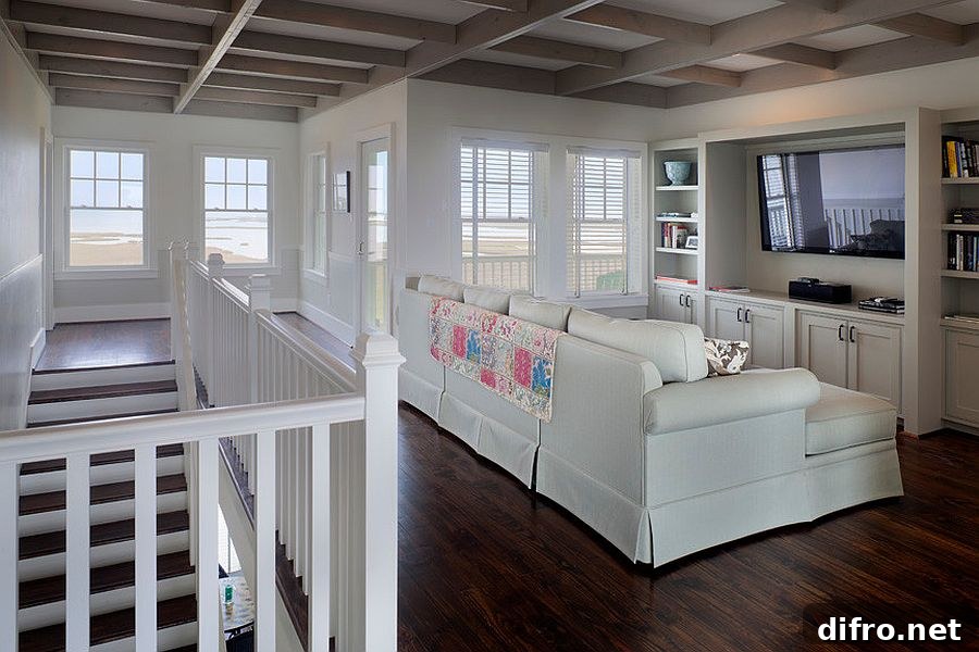 Staircase landing area turned into a smart home theater with a simple white sofa.