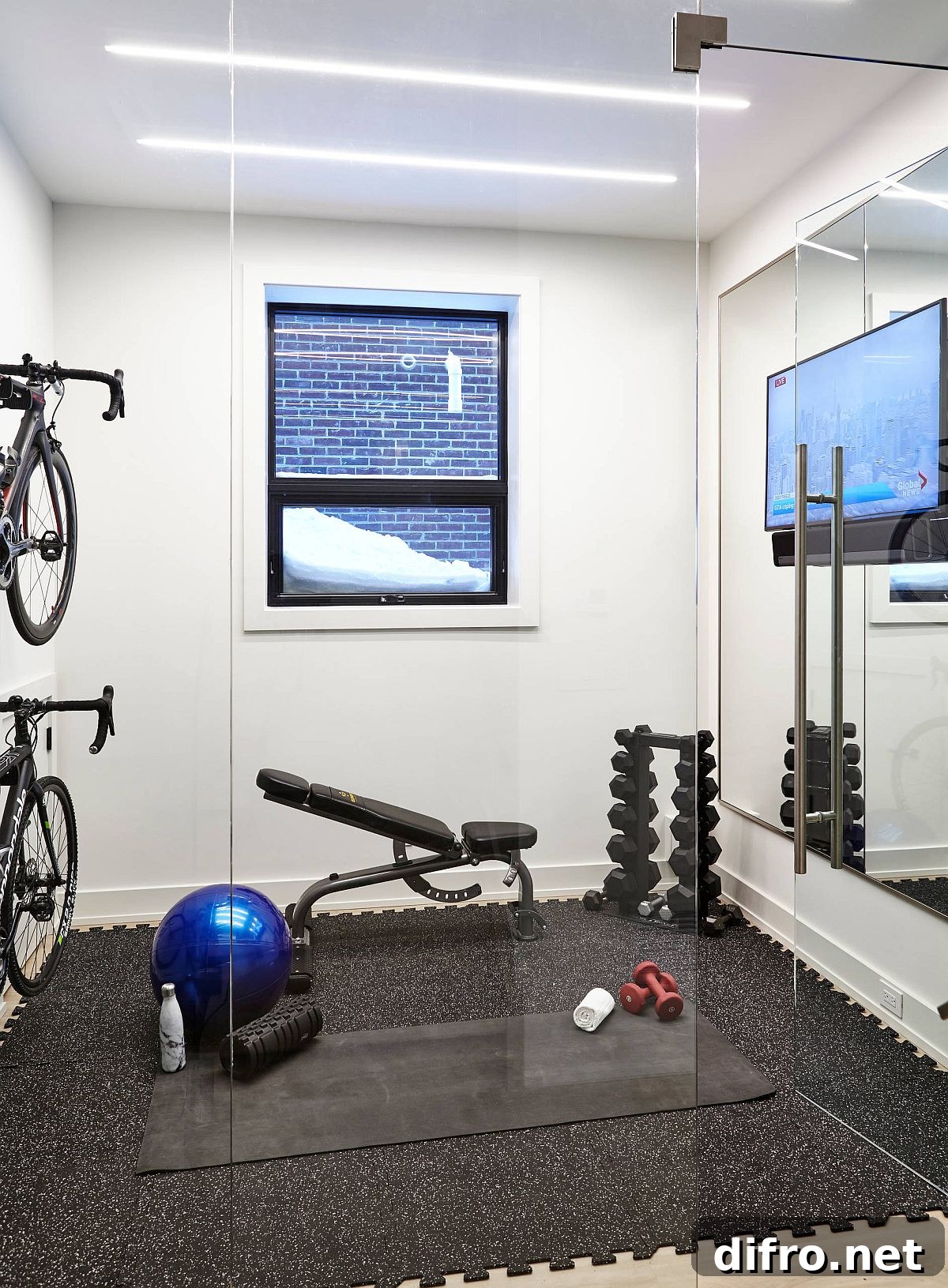 Well-lit small gym with padded flooring