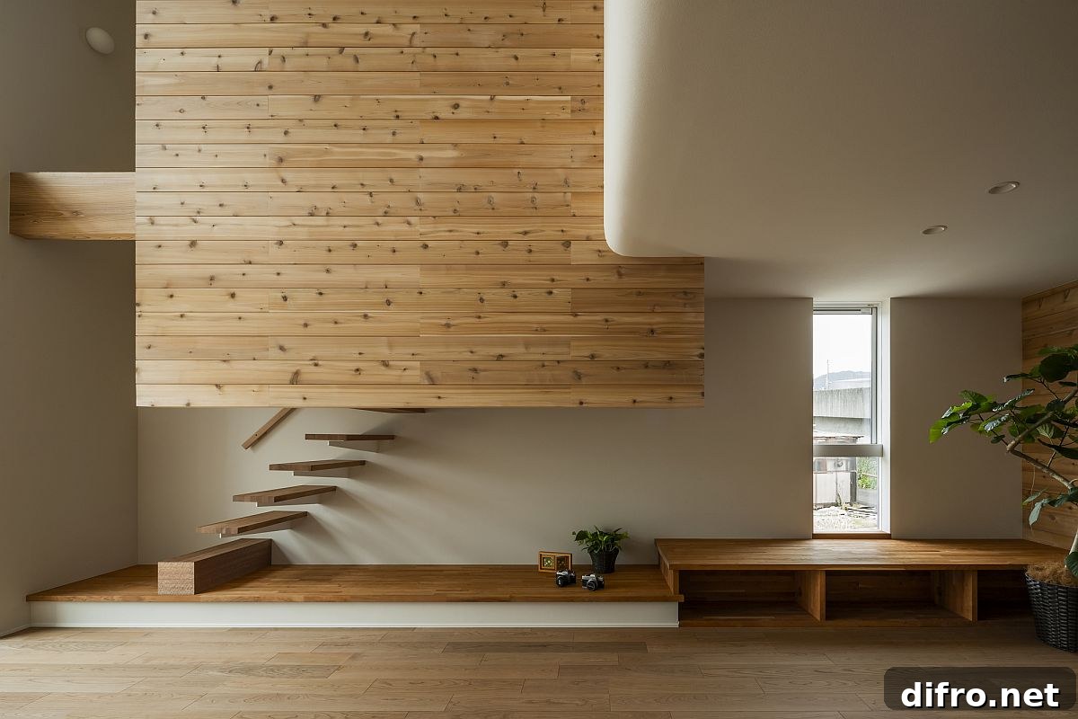 Double-height living area with floating staircase, wooden walls and ample natural light