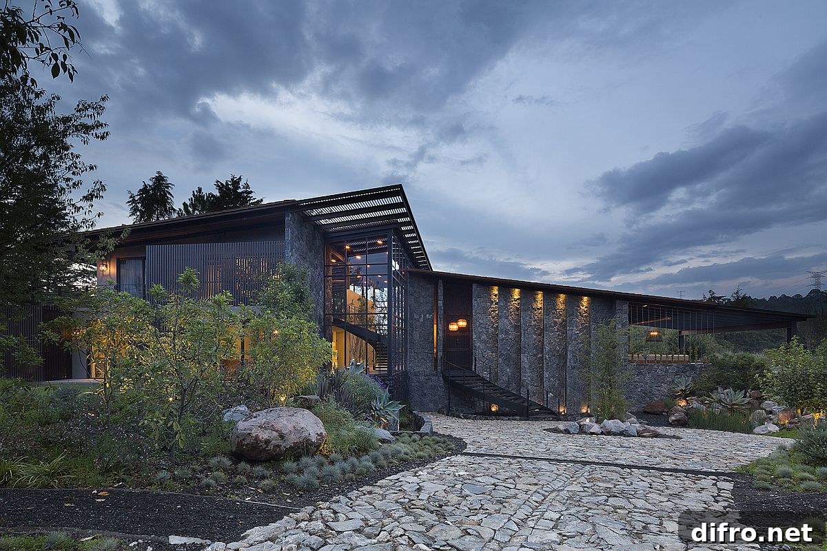 Exterior view of LS House showing dark volcanic stone walls and slanted roofs