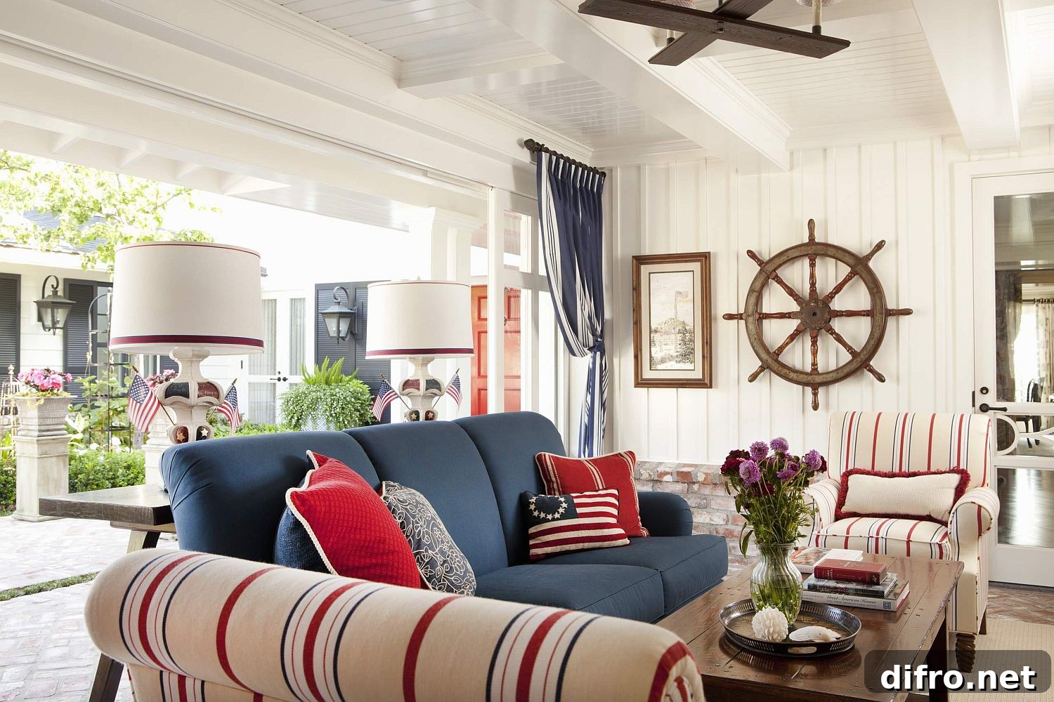 Beach-style porch with bright couch and striped chairs in cream, blue and red