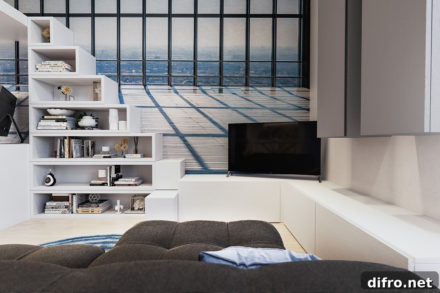 TV in the corner, loft bed steps turned into an open shelf and custom cabinets with ample storage in the living area