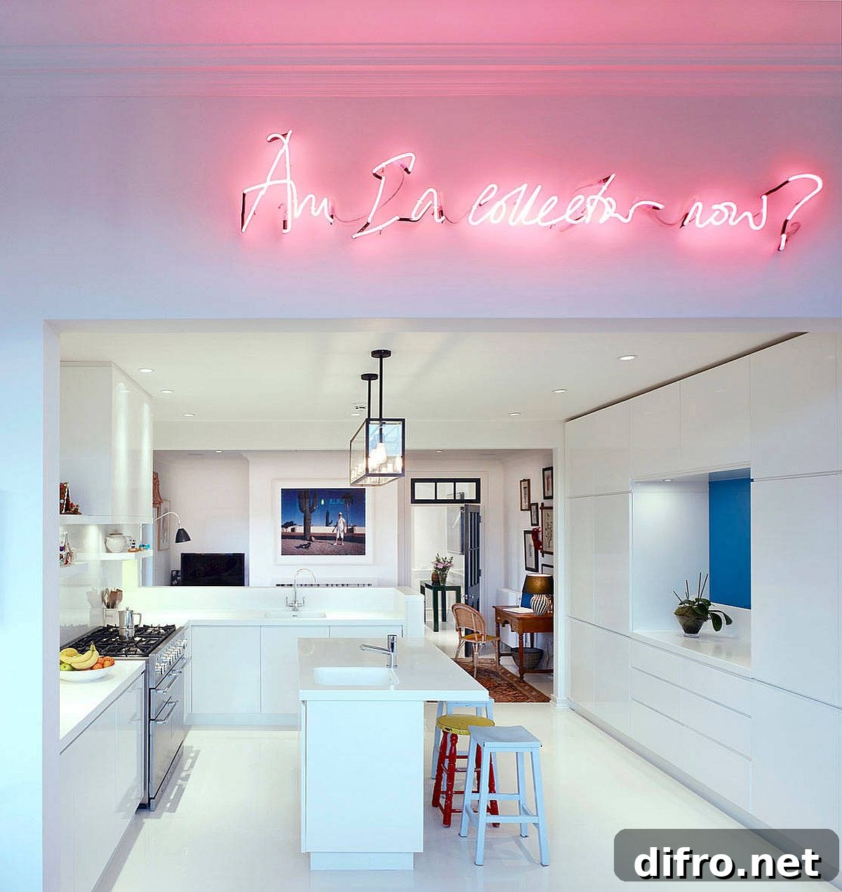Bright neon sign illuminates the kitchen and living area inside this white Chelsea apartment