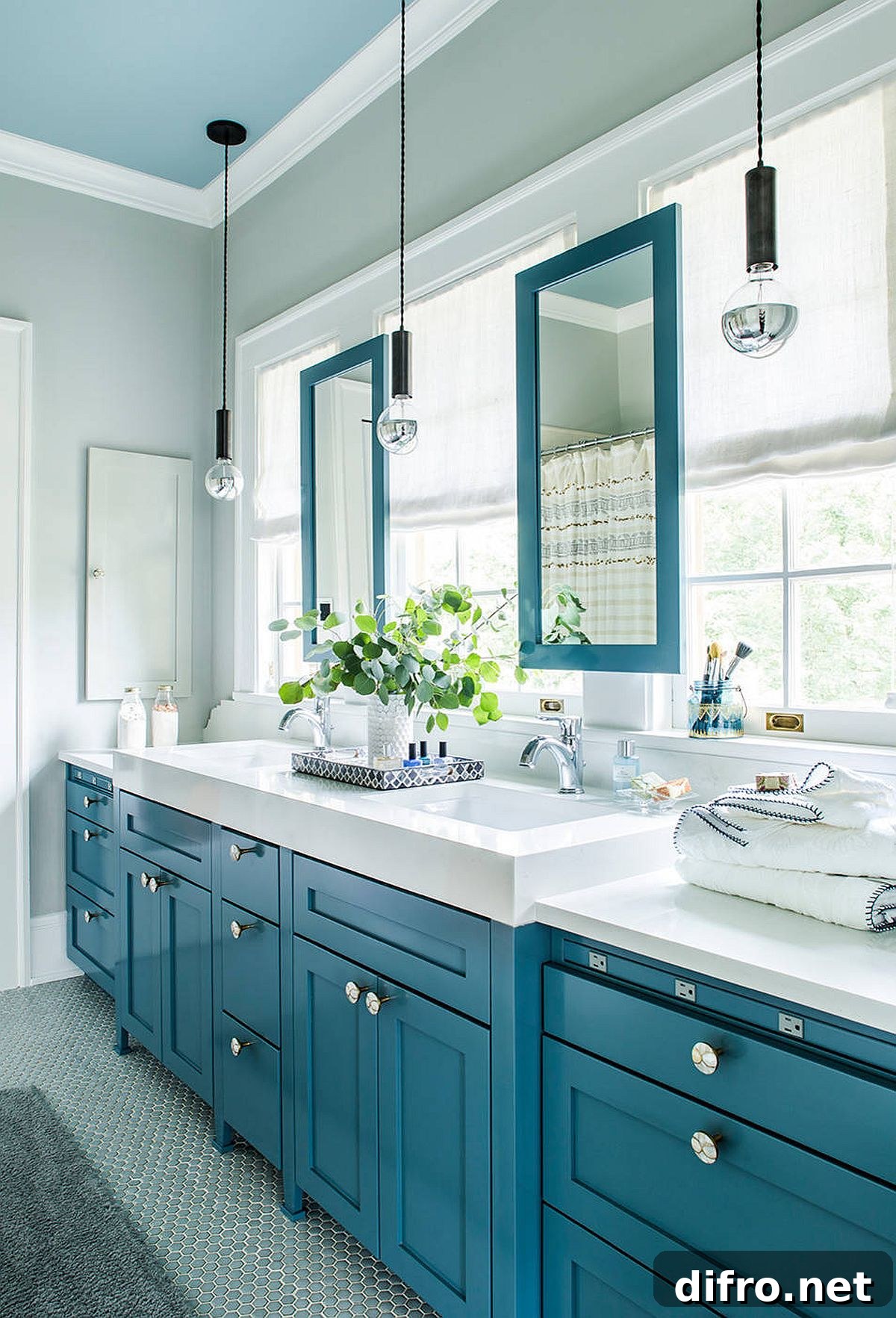 Gray bathroom with blue cabinetry, mirror frames and ceiling