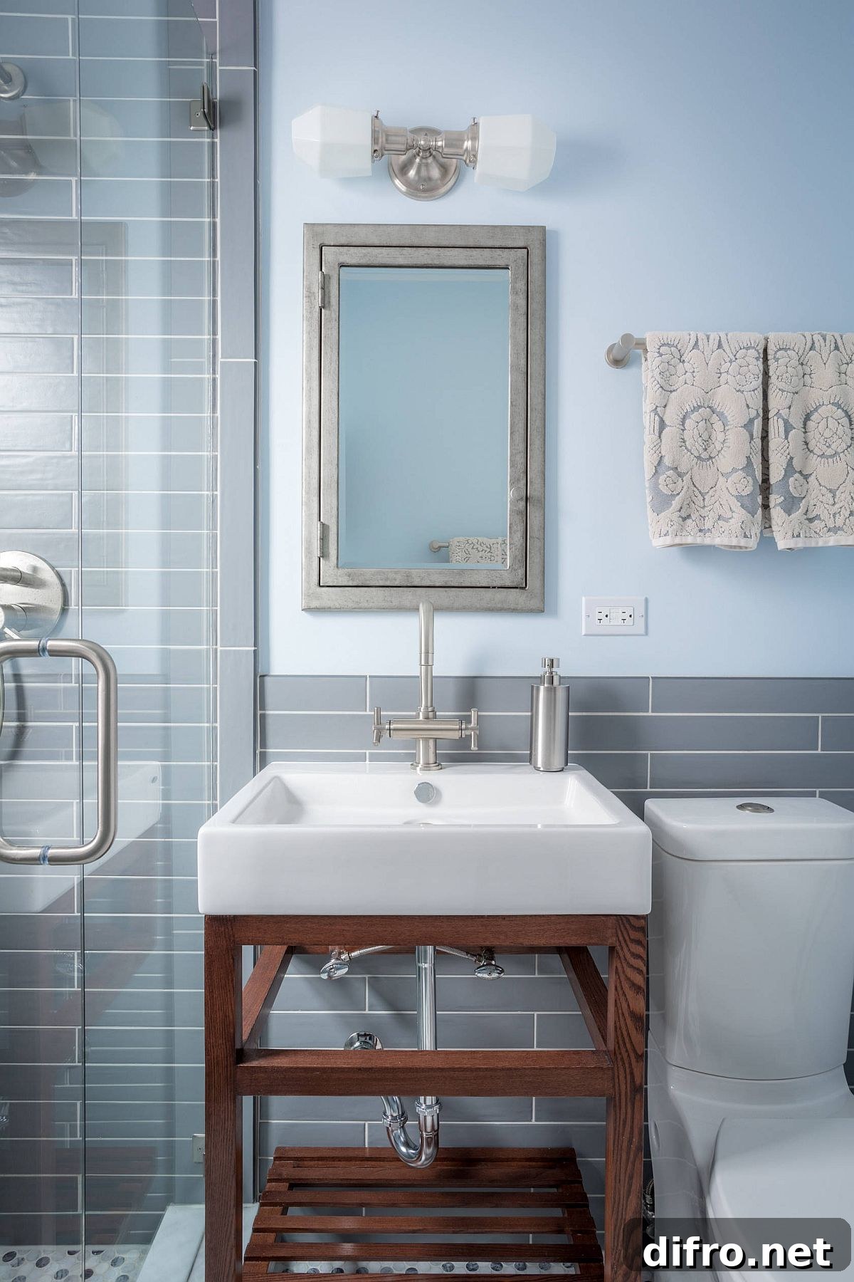 Modern gray and blue bathroom with wooden vanity and warm lighting