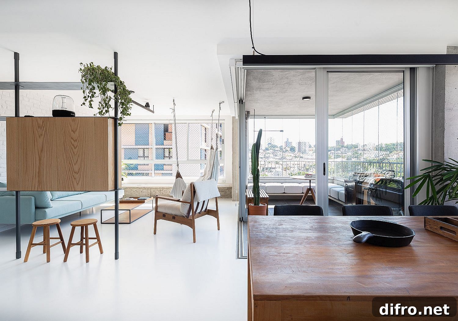 Living area with a room divider that doubles as a TV stand and a balcony visible beyond