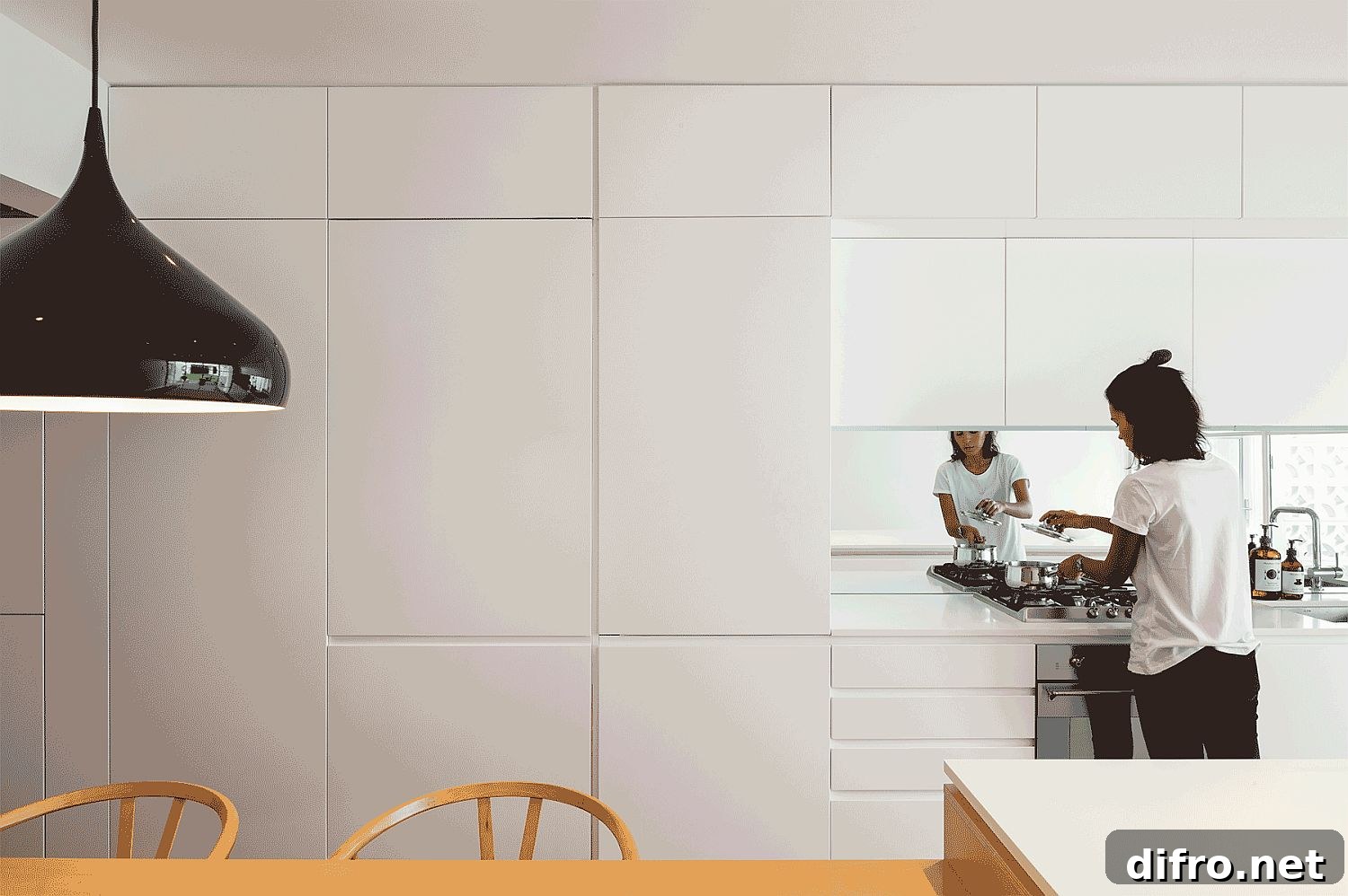 Black accents make a big impression in this all white kitchen area