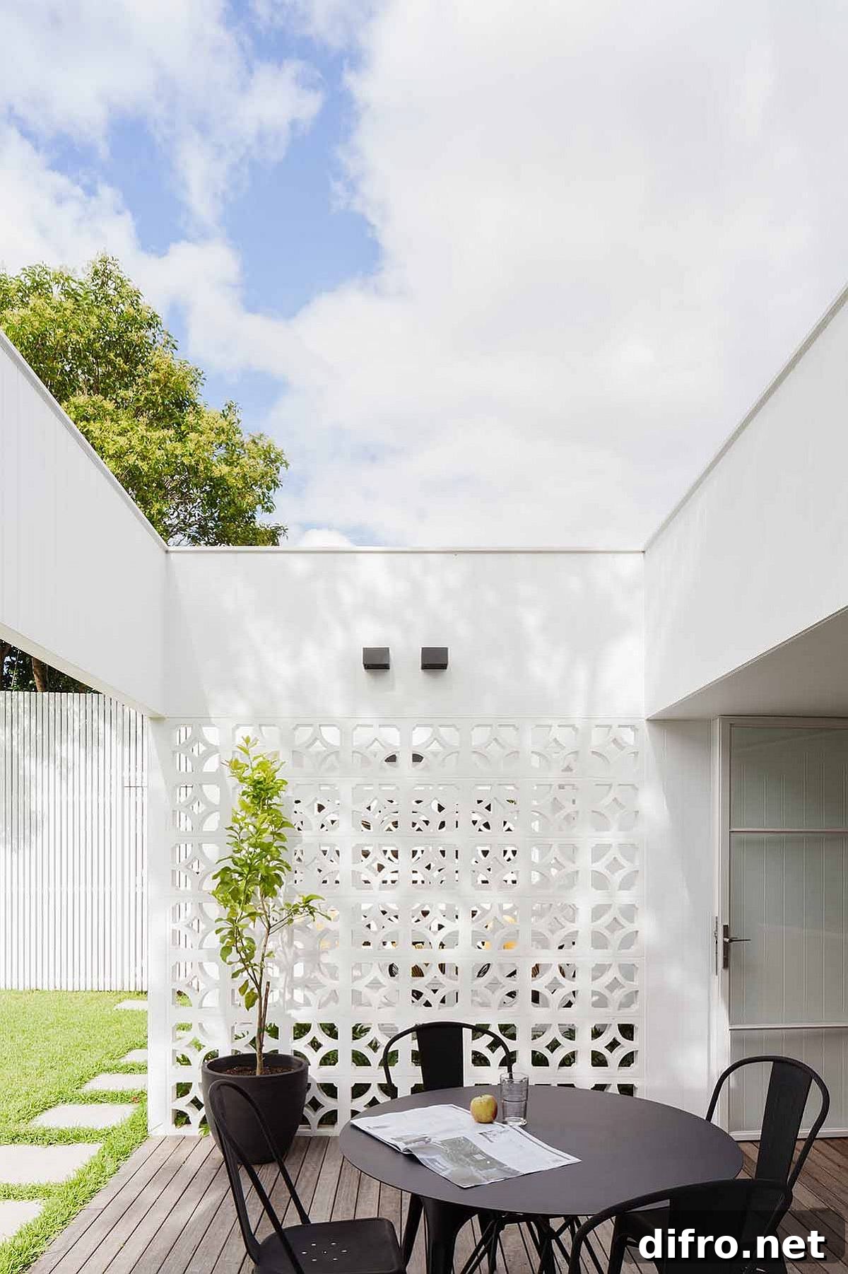 Large wooden decks with dining areas connect the interior with the rear yard