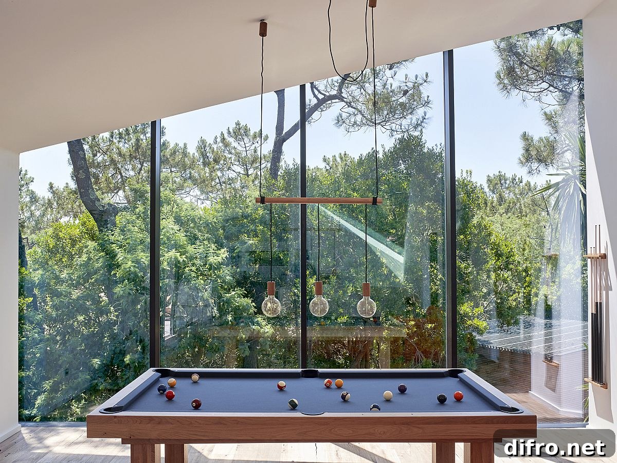 Game room on the upper level with glass walls offers lovely views of the landscape outside