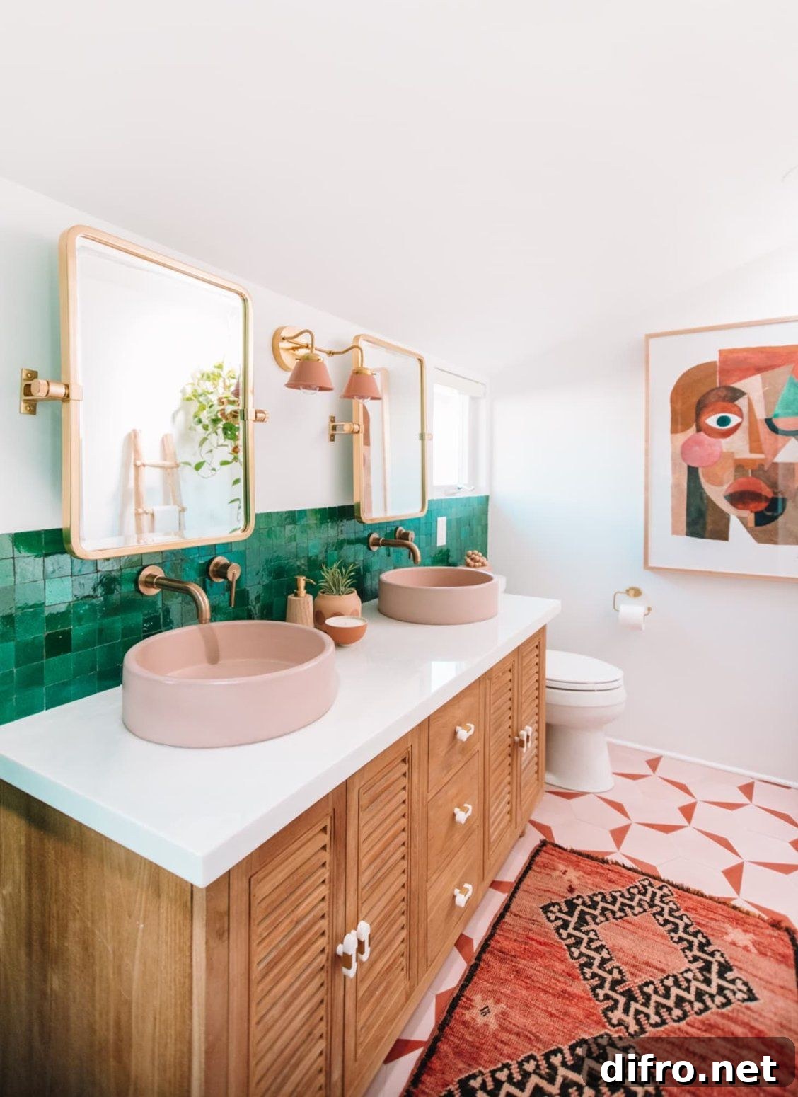 Pair of gold-trimmed mirrors over pink sinks