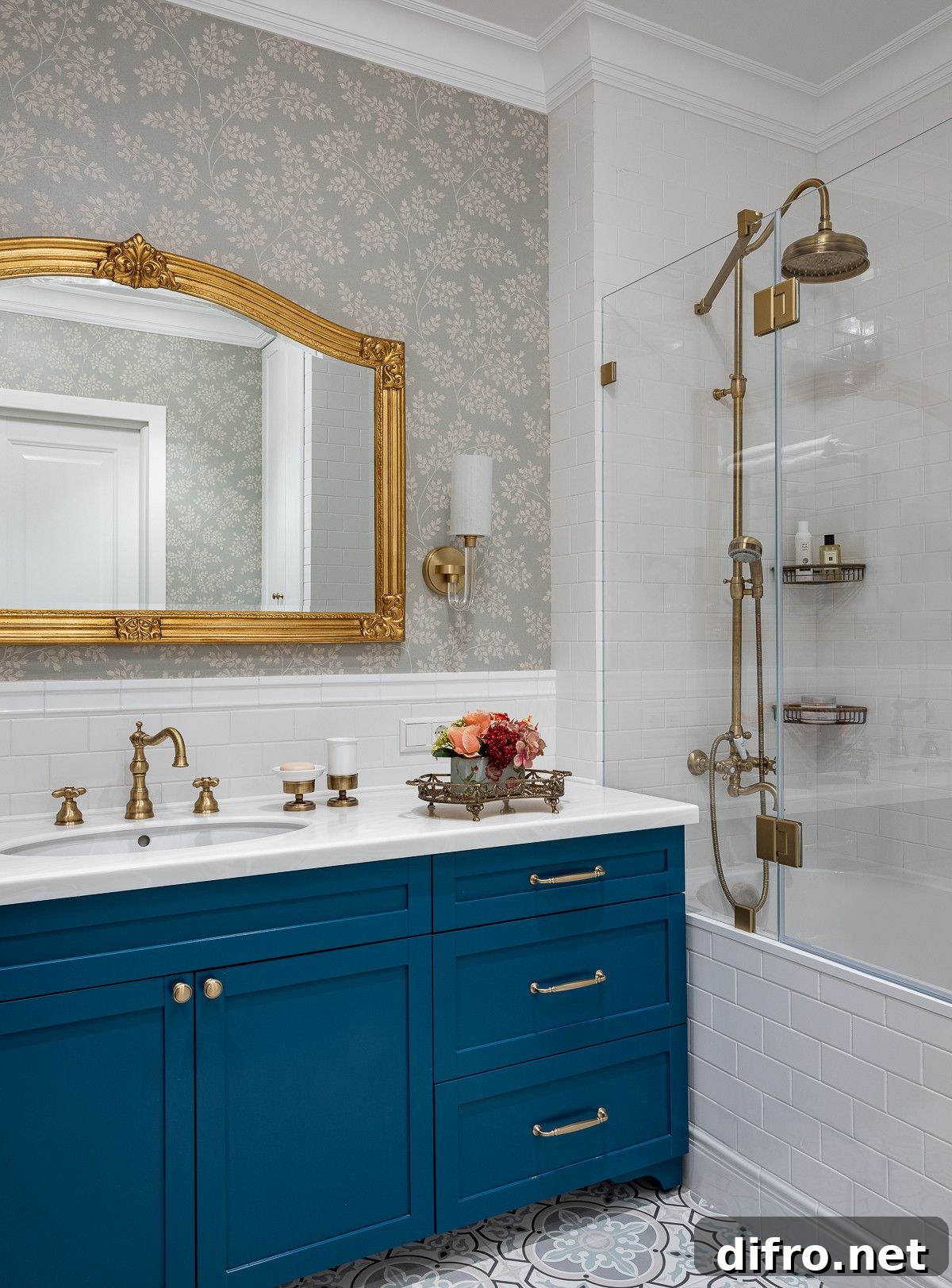 Modern bathroom in white with blue vanity and a mirror that features golden frame