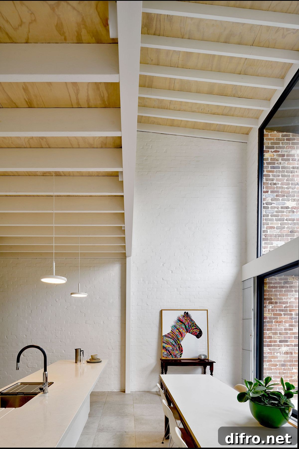 Double-height kitchen and dining area of the house with ample natural light and a modern-classic appeal