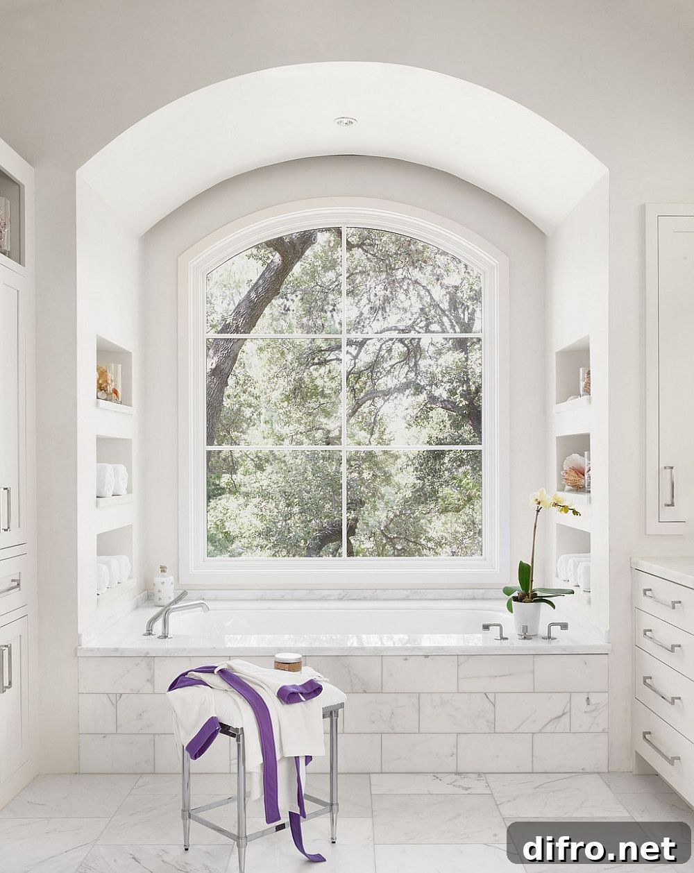 All-white modern bathroom overlooking leafy outdoors