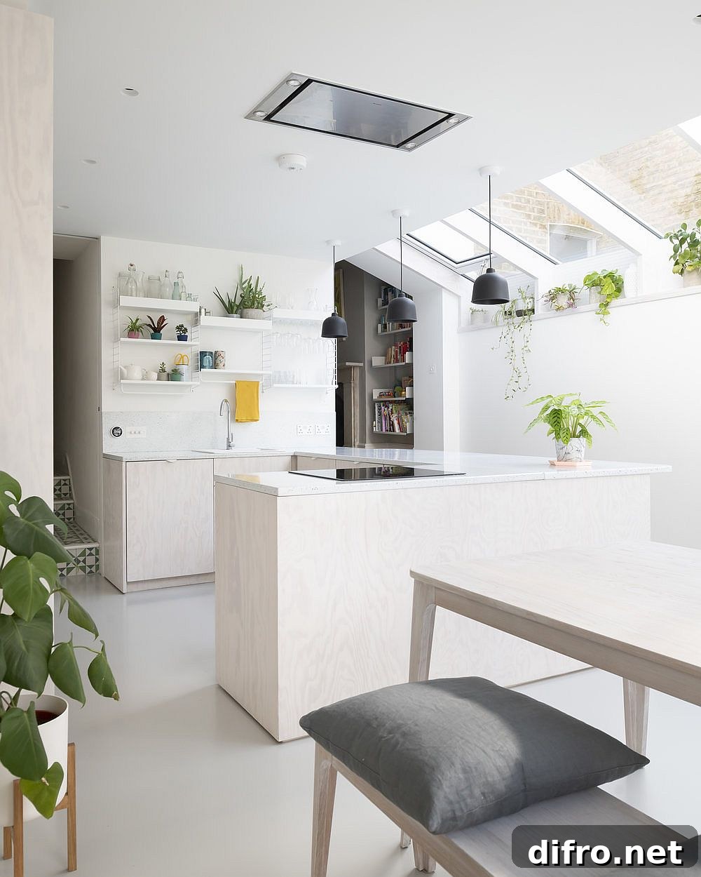 Greenery and accents in the kitchen bring color to an otherwise neutral interior in white