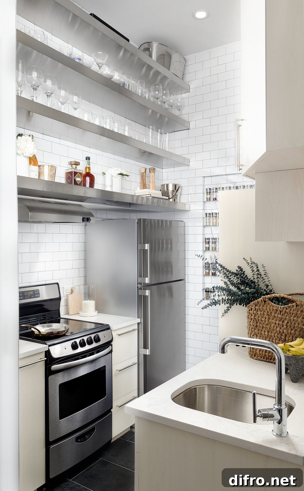 Tiny kitchen with stainless steel appliances and white tiled walls