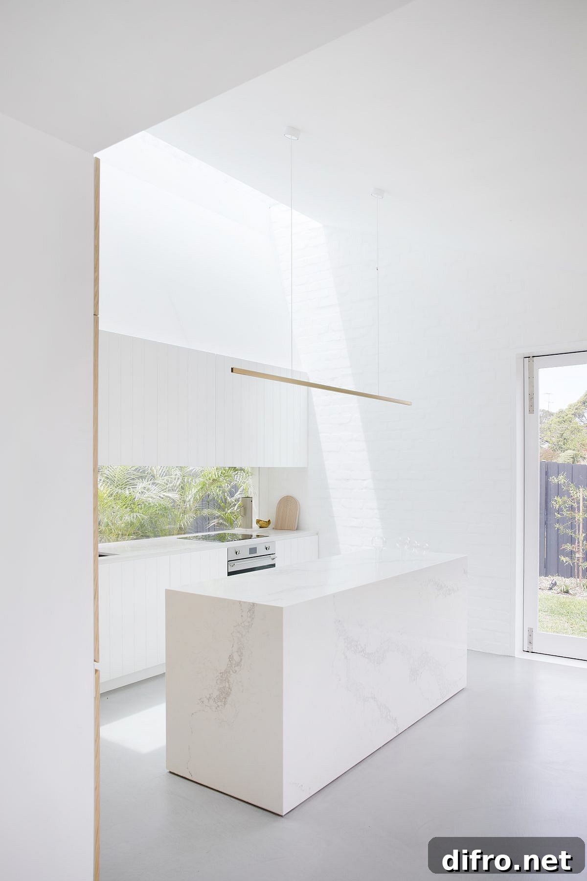 Contemporary white kitchen with painted brick walls and marble island