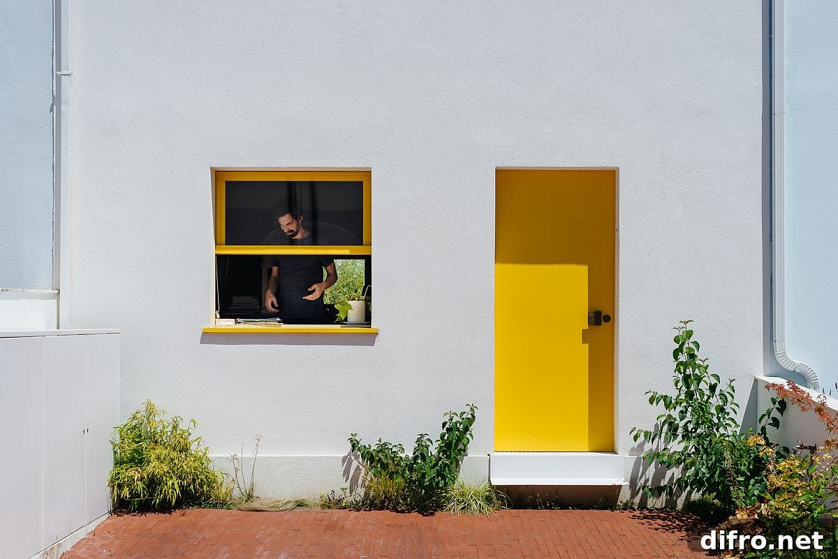 Yellow doors and window frames on white exterior