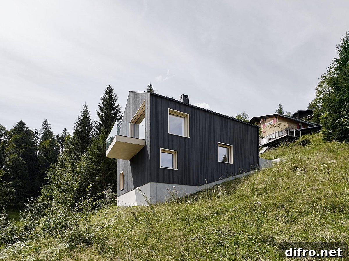 Building on the sloped site overlooks the valley and surrounding forest in Austria