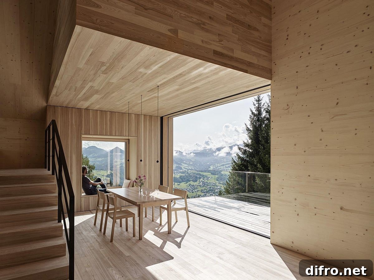 Interior clad in lighter wood split across multiple levels offers views of the landscape