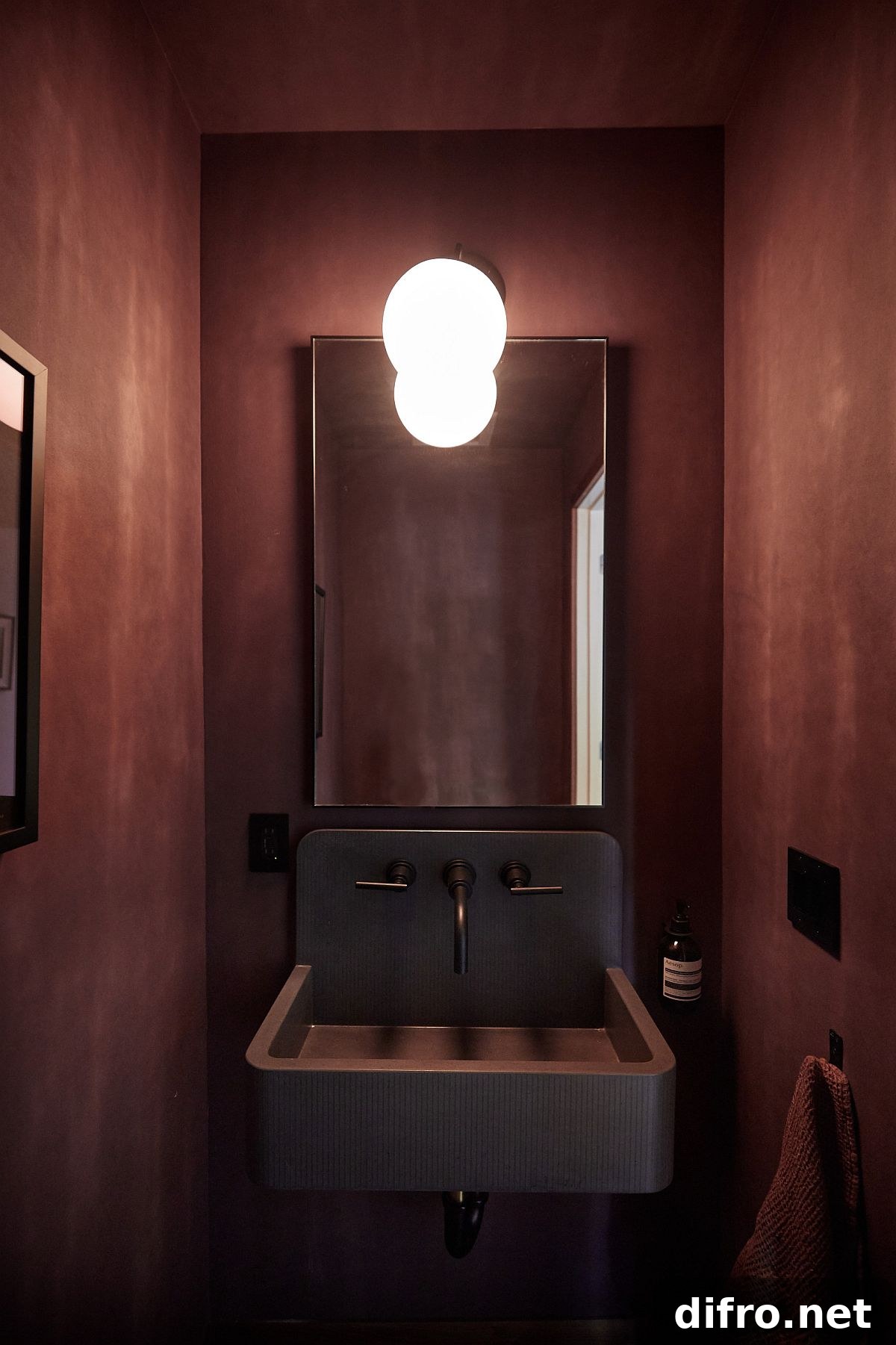 Textured deep red walls in a small powder room