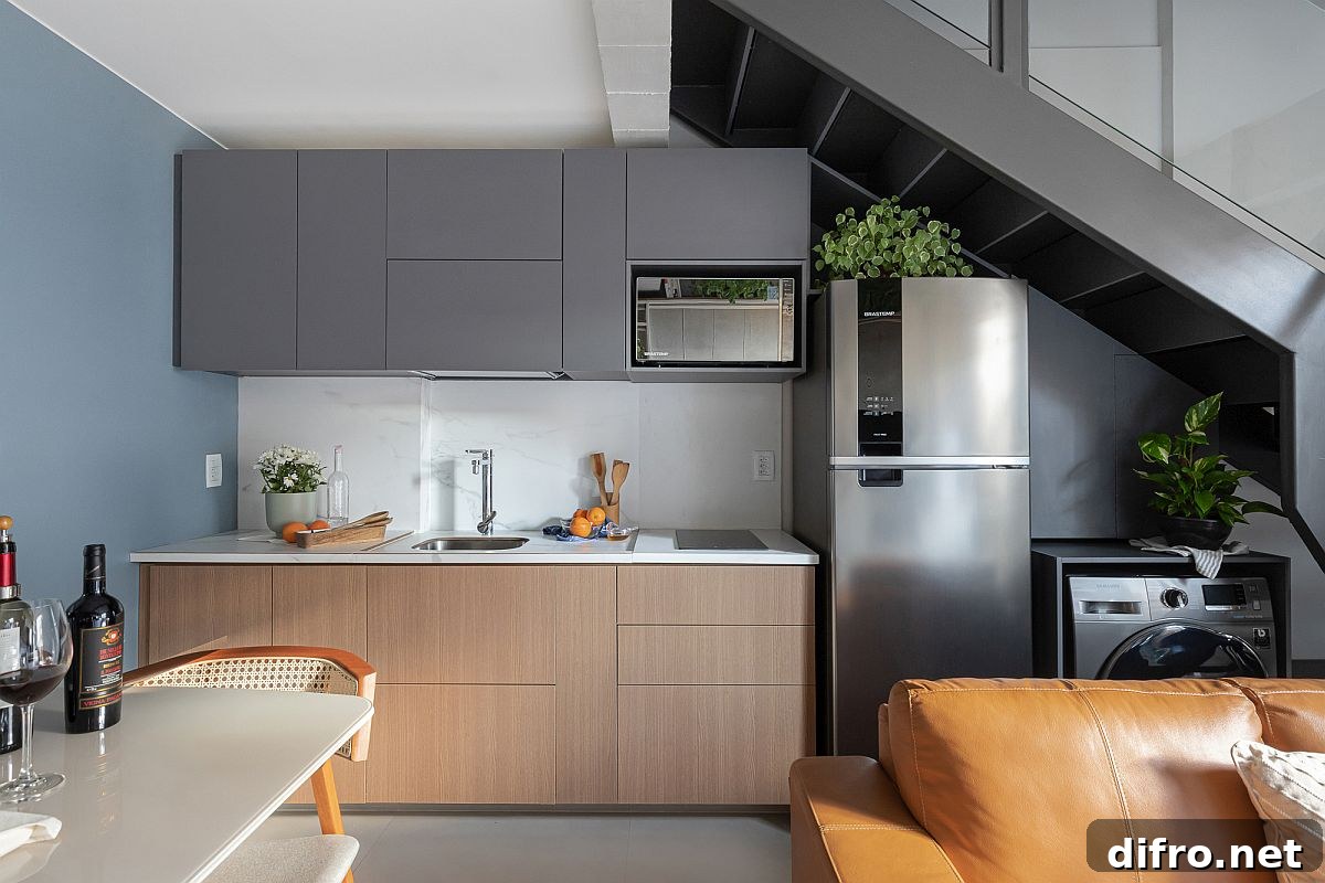 Kitchen wall under the extended mezzanine with dark gray cabinets and appliances