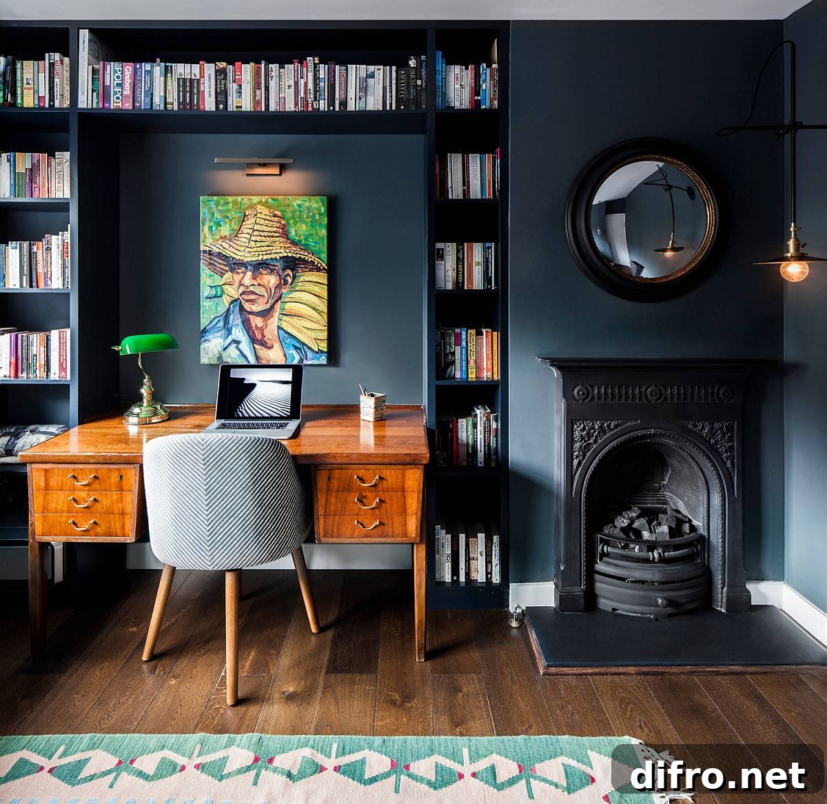 Bookshelves around the desk in a dark bluish-gray eclectic home office
