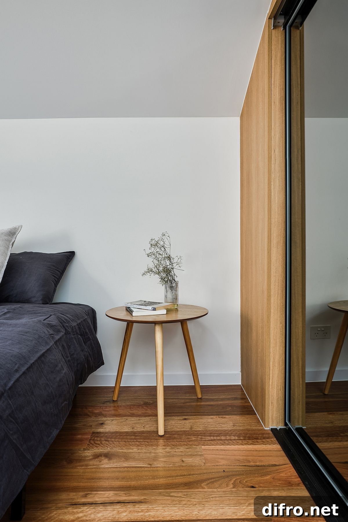 Modern white bedroom with wooden floor and mirrored wardrobe