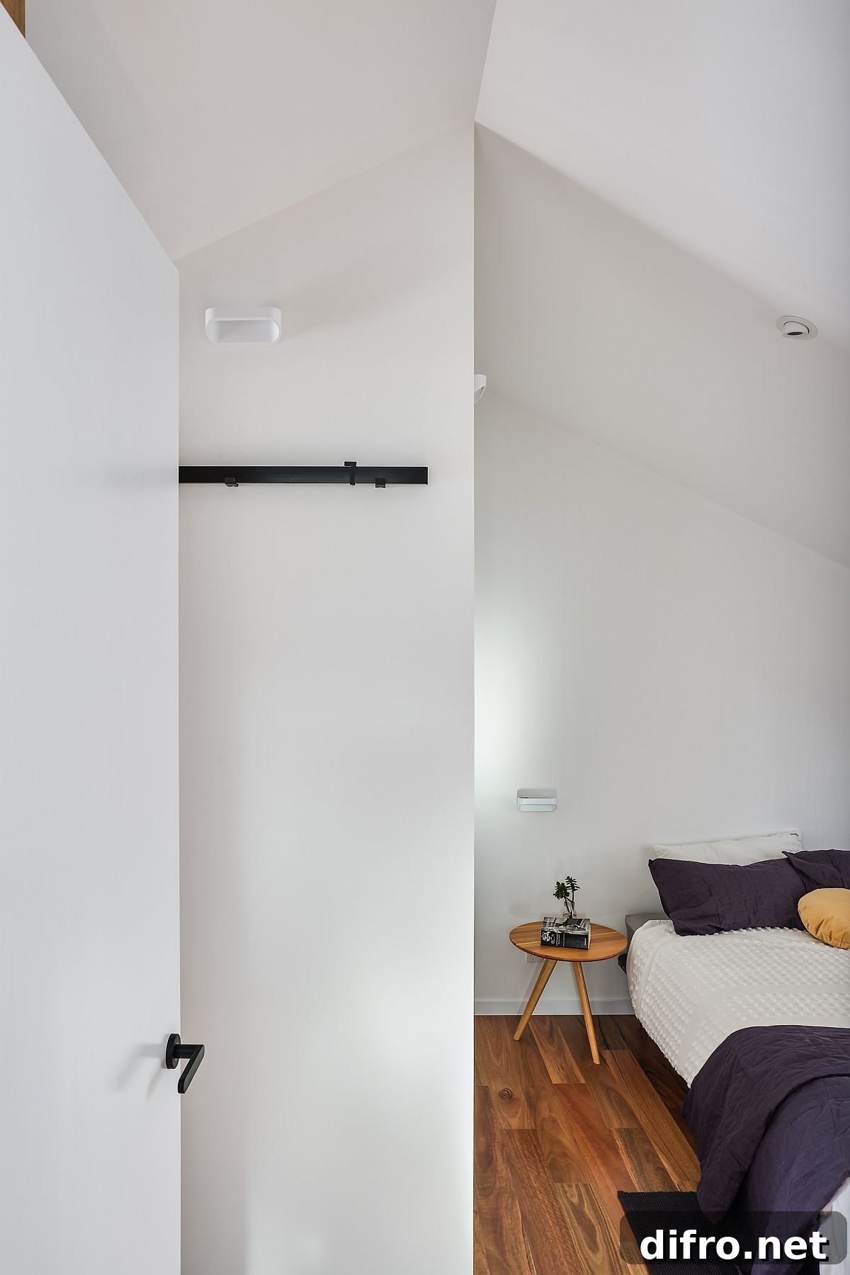 Attic bedroom with white walls and timber floor
