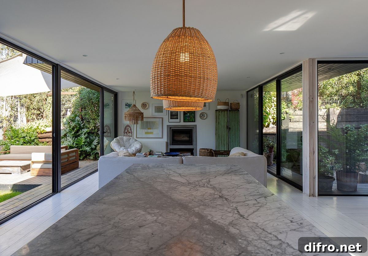 Open plan living area of the house with kitchen and dining space along with patios on both ends