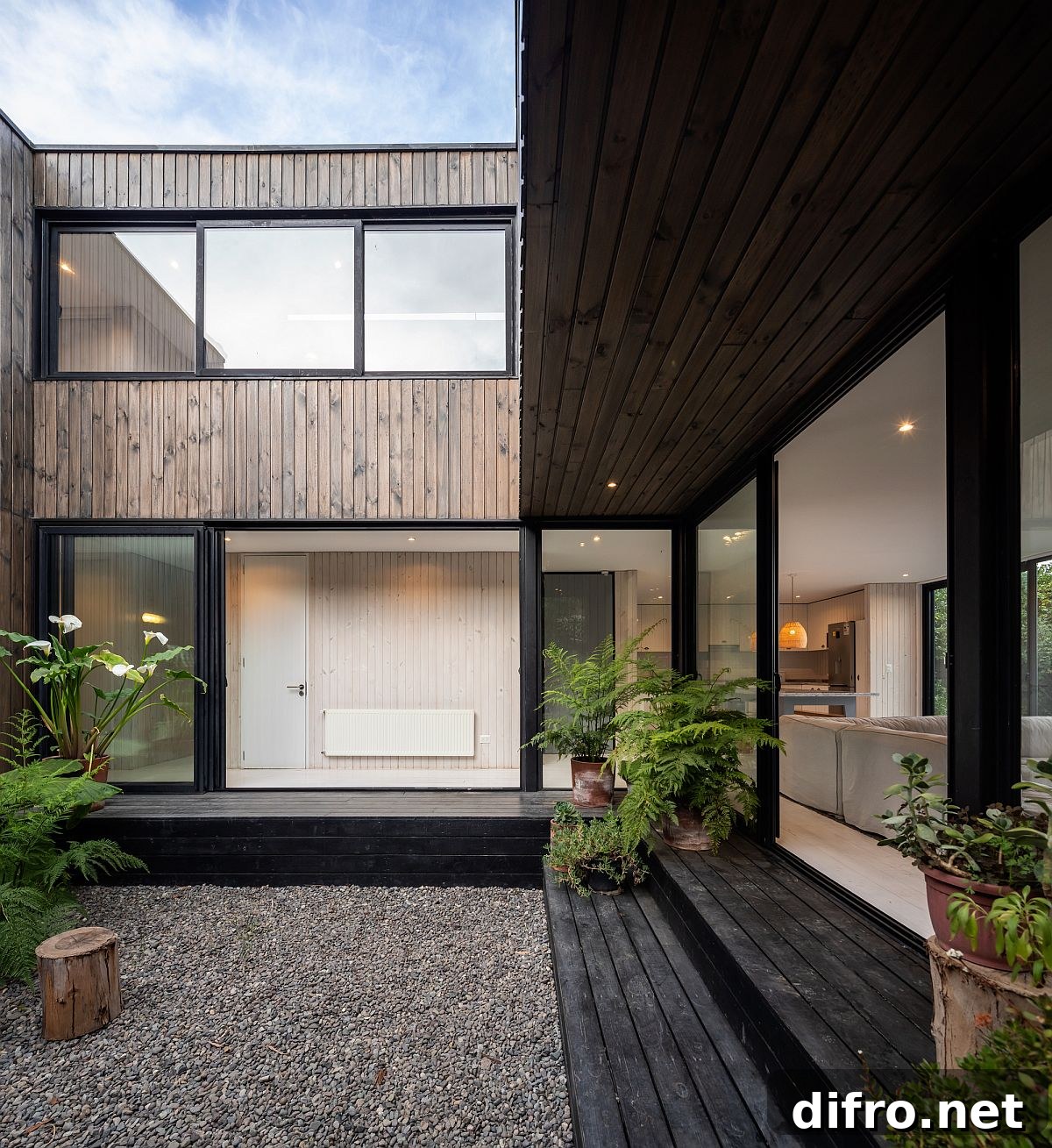Sliding glass doors with steel frame and wood shape the exterior of the house