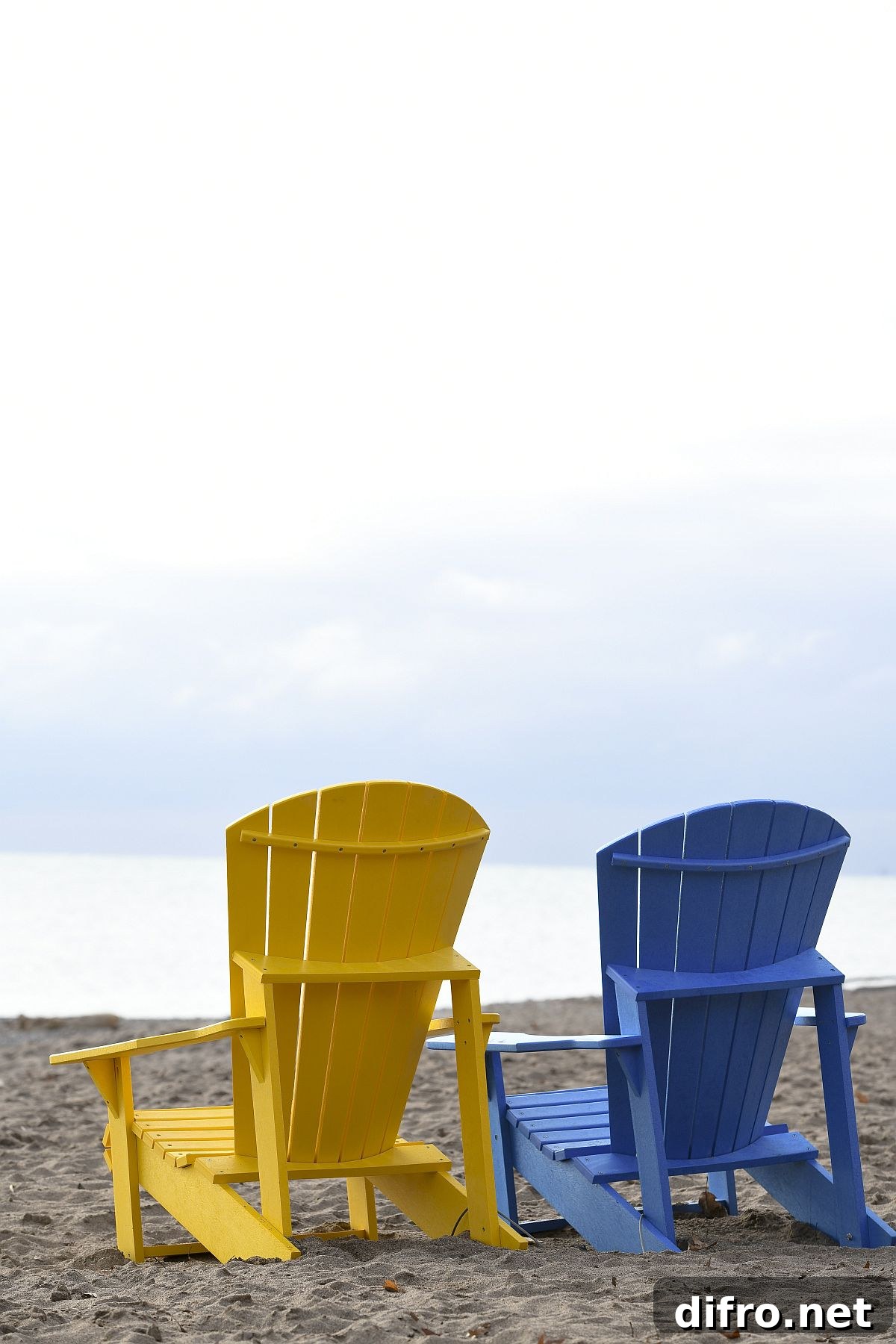 Colorful wooden chairs on the beach with views of the waves