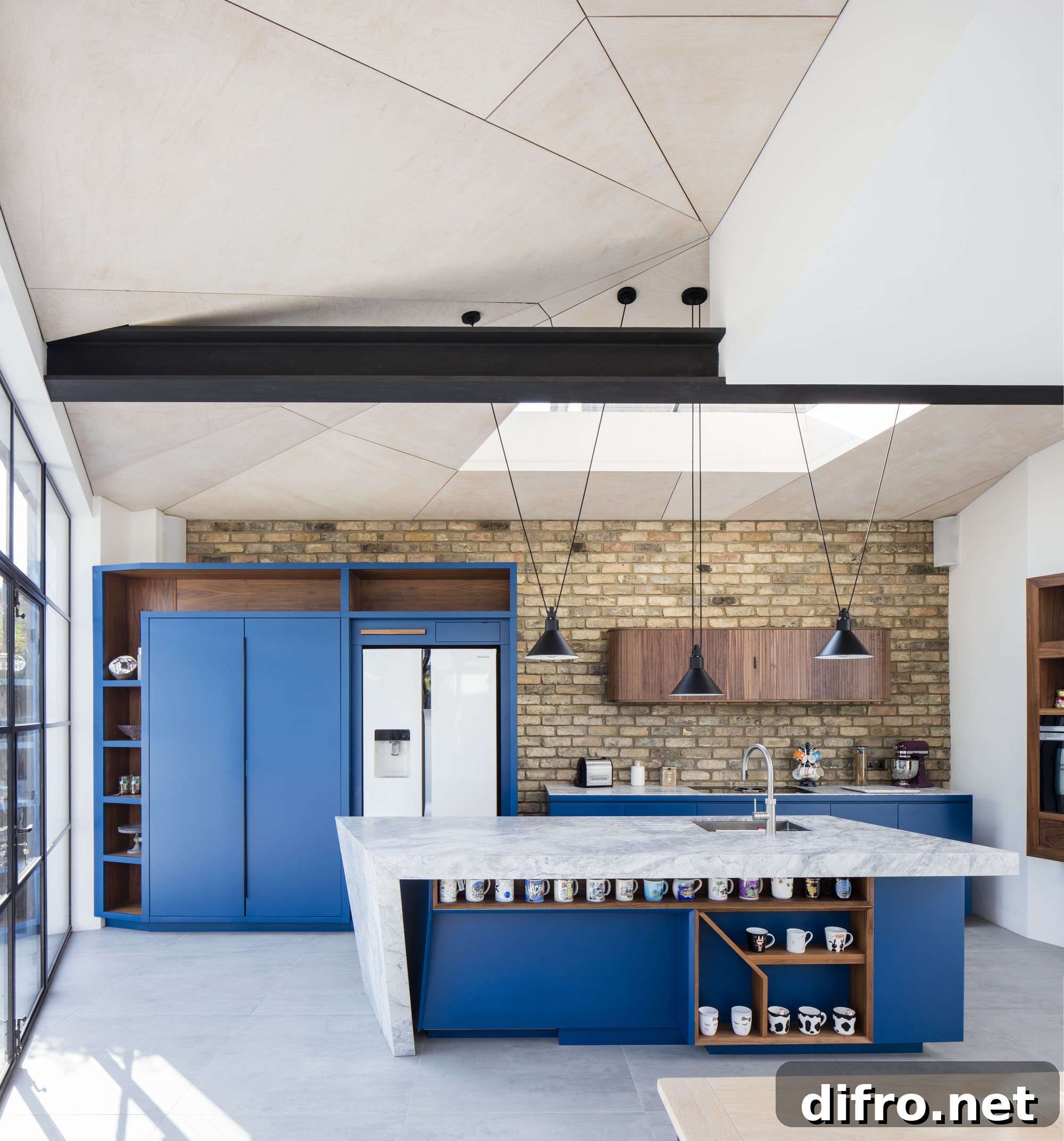 New kitchen of renovated family home in London with brick wall backdrop and blue cabinets