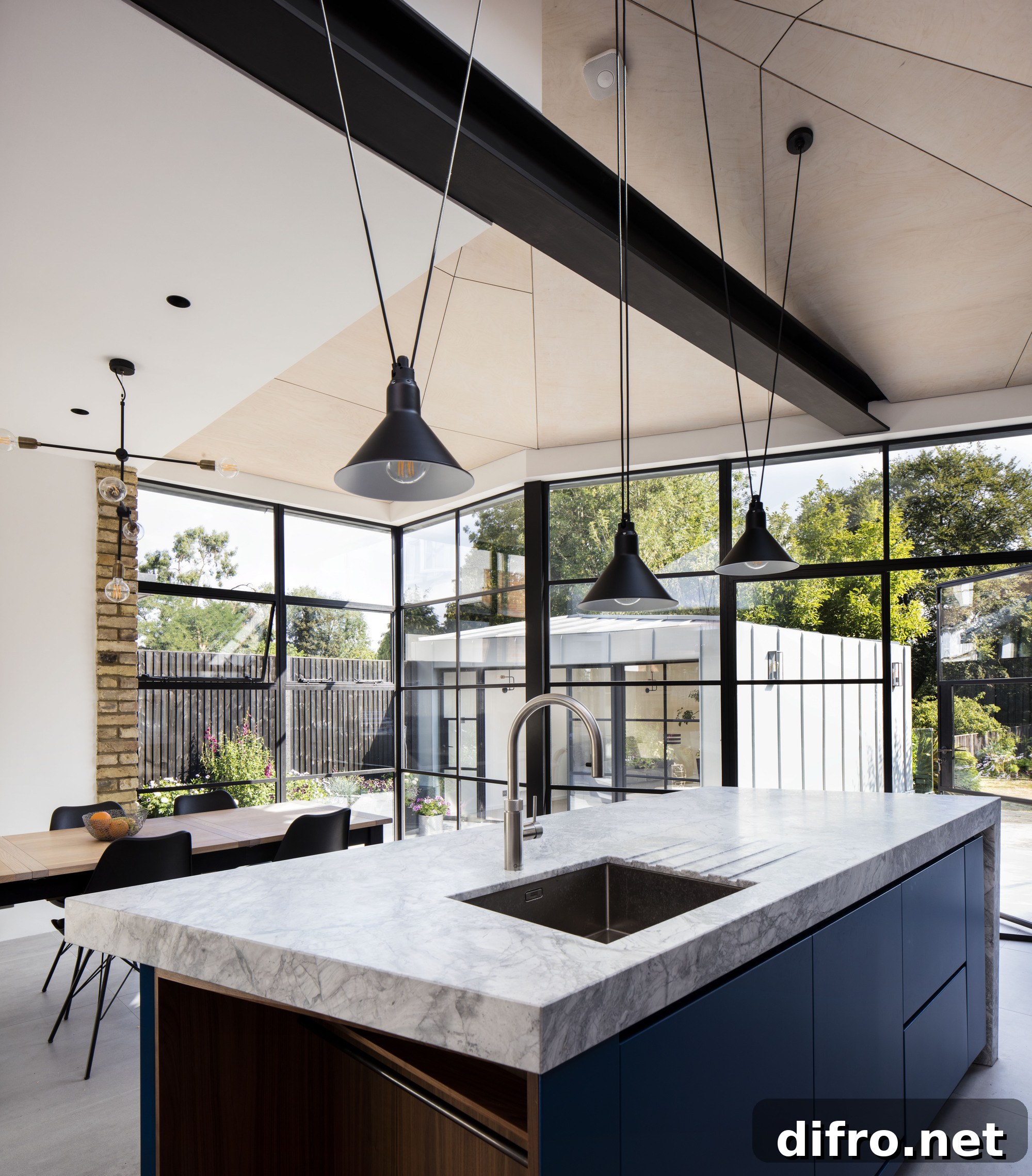Angular plywood roof, custom kitchen island and dining space of the renovated London home