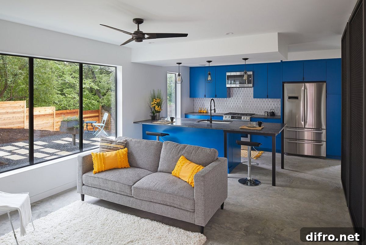 Modern kitchen inside the Texas home with bright blue cabinets and a relaxing sitting area next to it