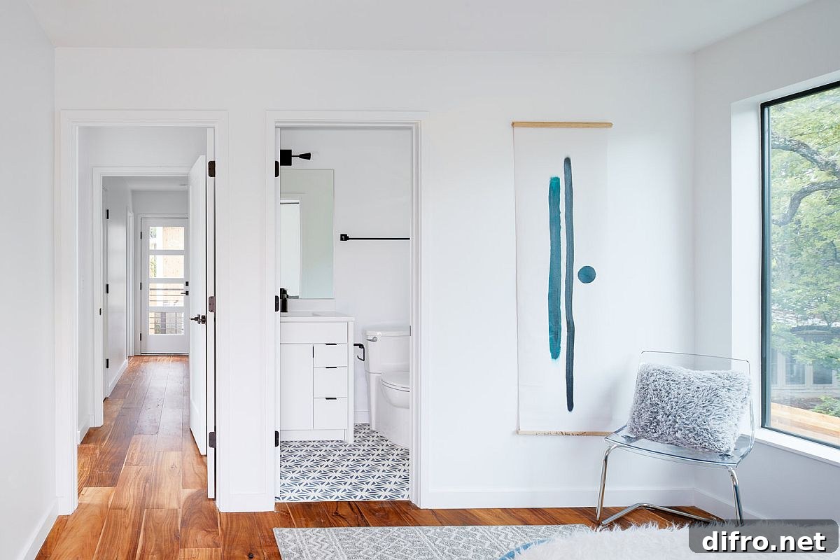 Wooden floor delineates the bedroom from the bathroom next to it with patterned floor tiles