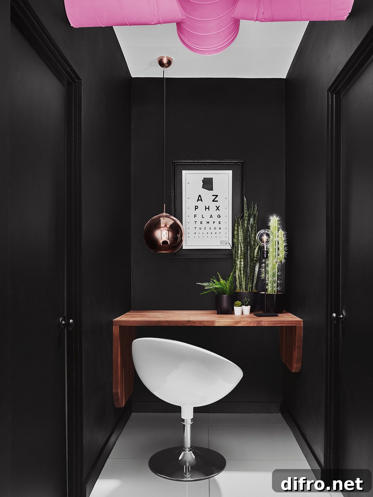 Small black home office with built-in wooden desk and copper pendant light