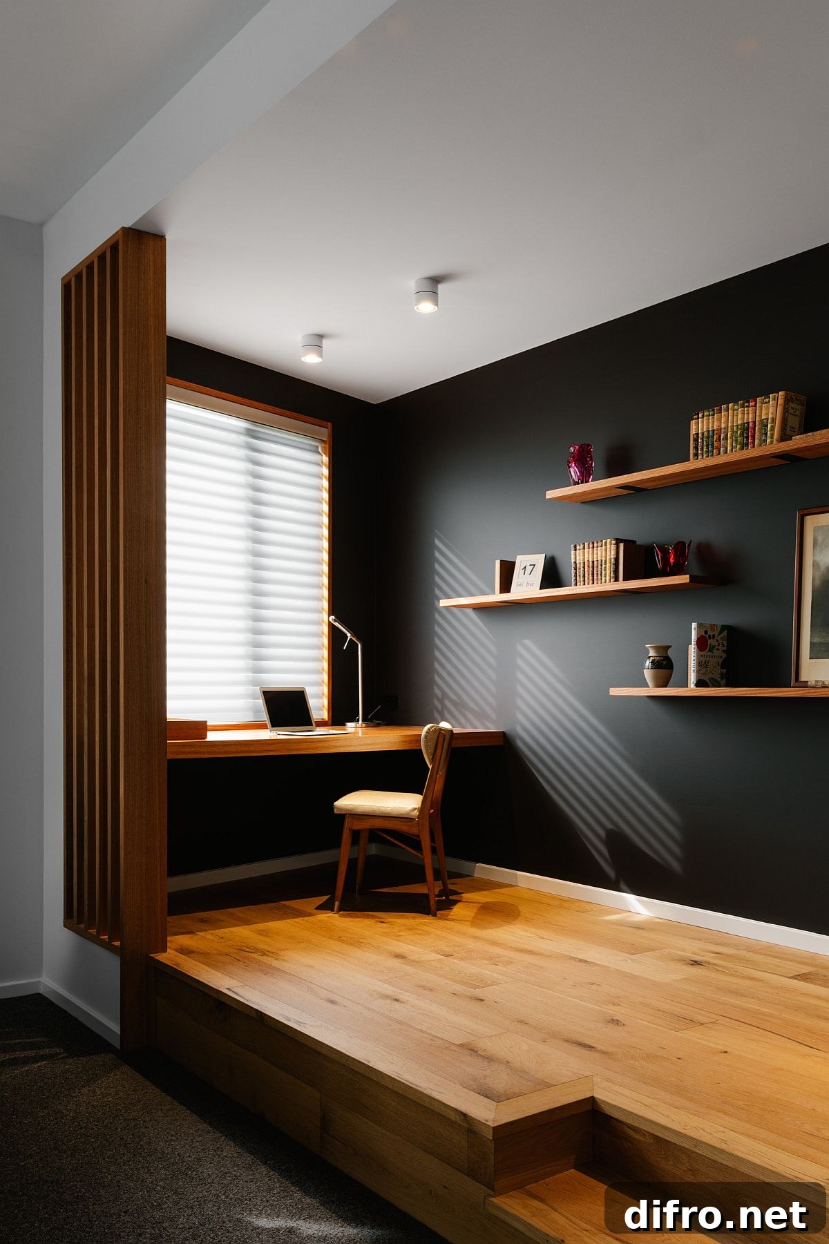 Raised wooden floor delineates this black and wood home office from the living area