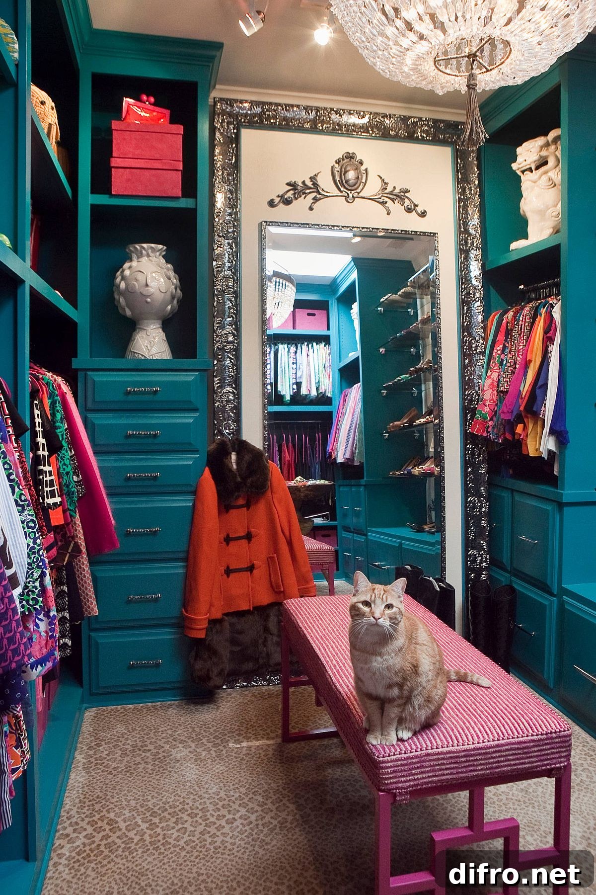 Small carpeted dressing room with blue cabinets and pink desk