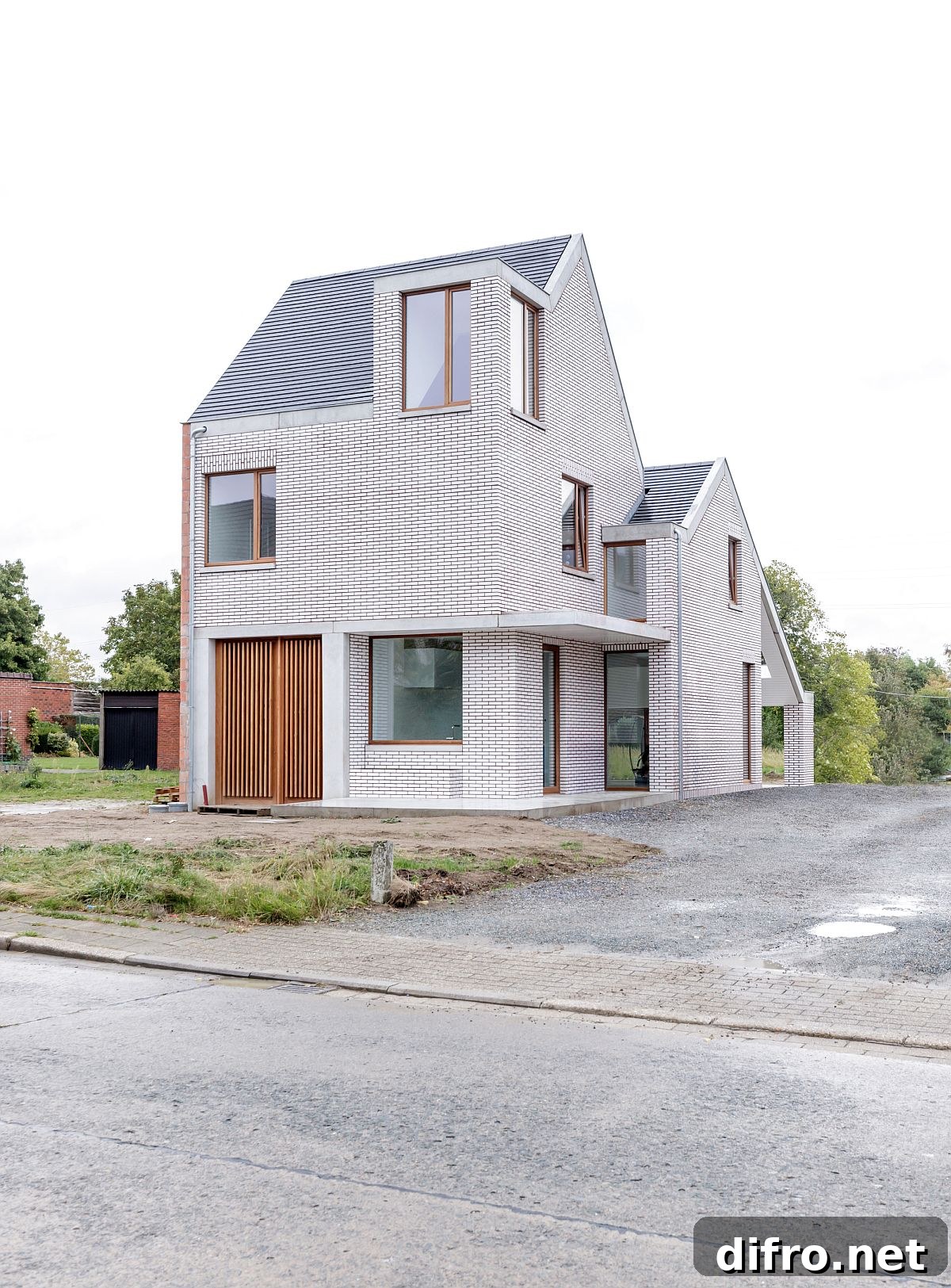 Wooden door and frames of the house give contrast to the facade of the house