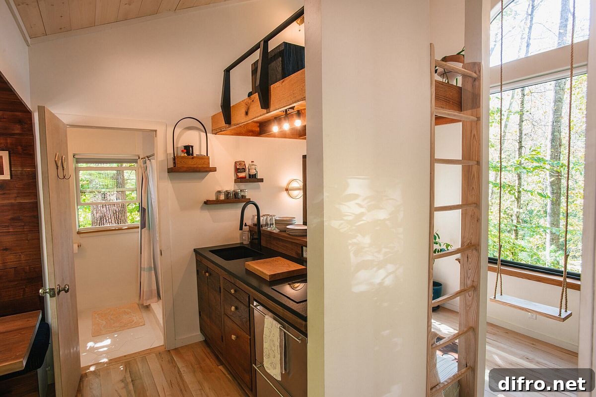Kitchen with loft level reading space above inside the small wooden cabin