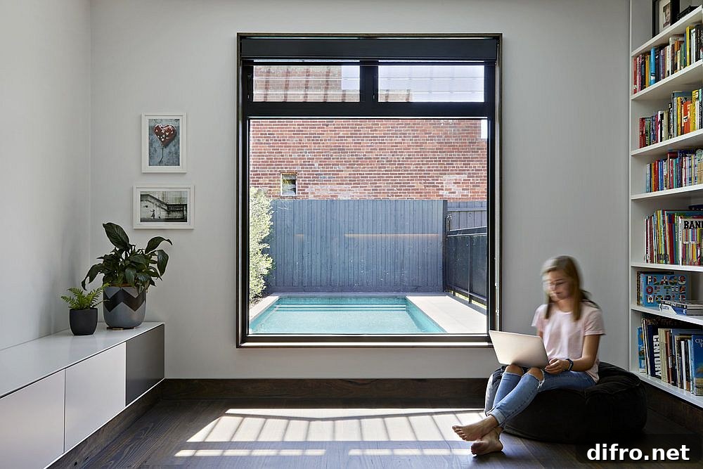 Sitting area and library with a window overlooking the pool