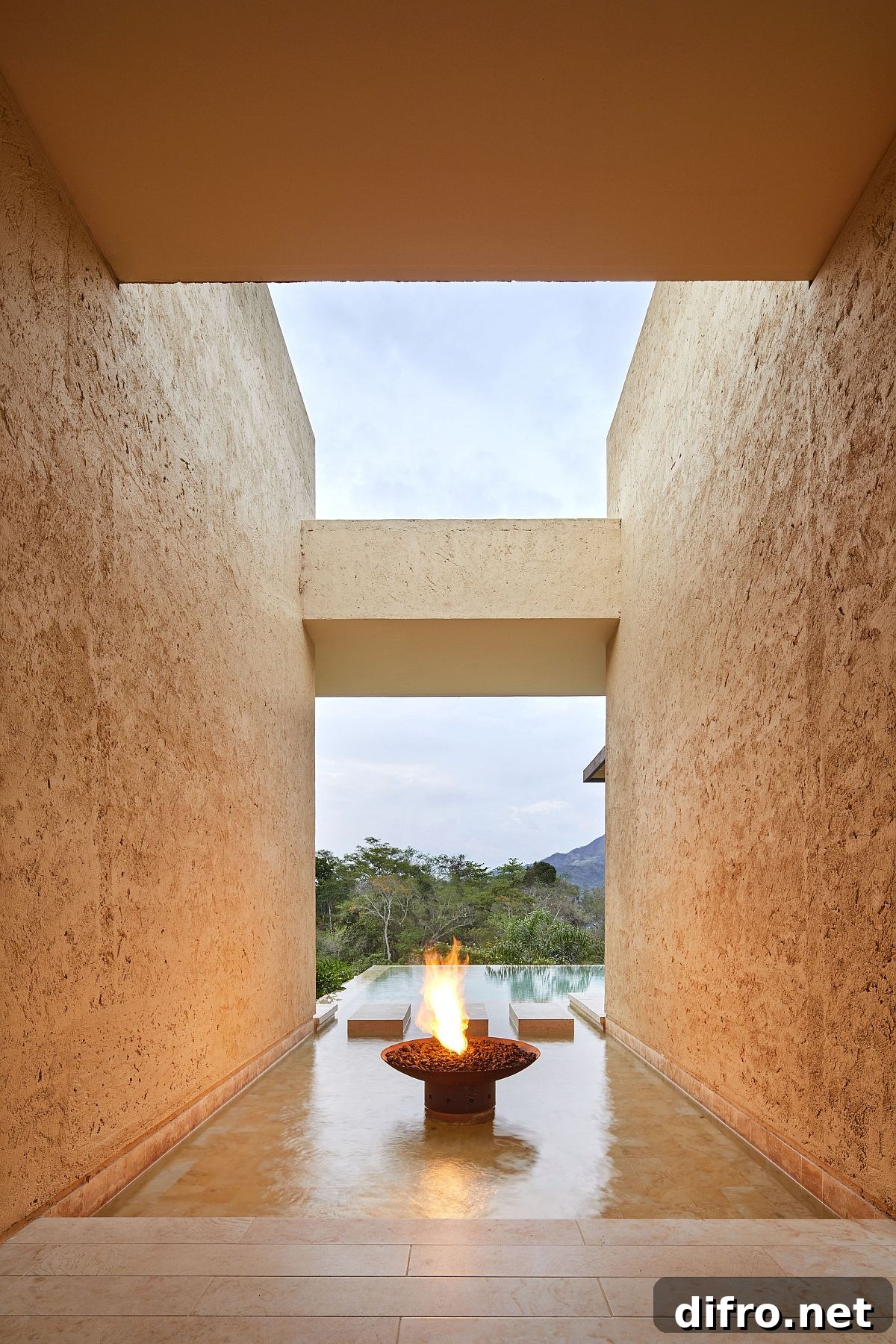 Stone walls that create entry to the pool deck create the illusion of fire and water at the house