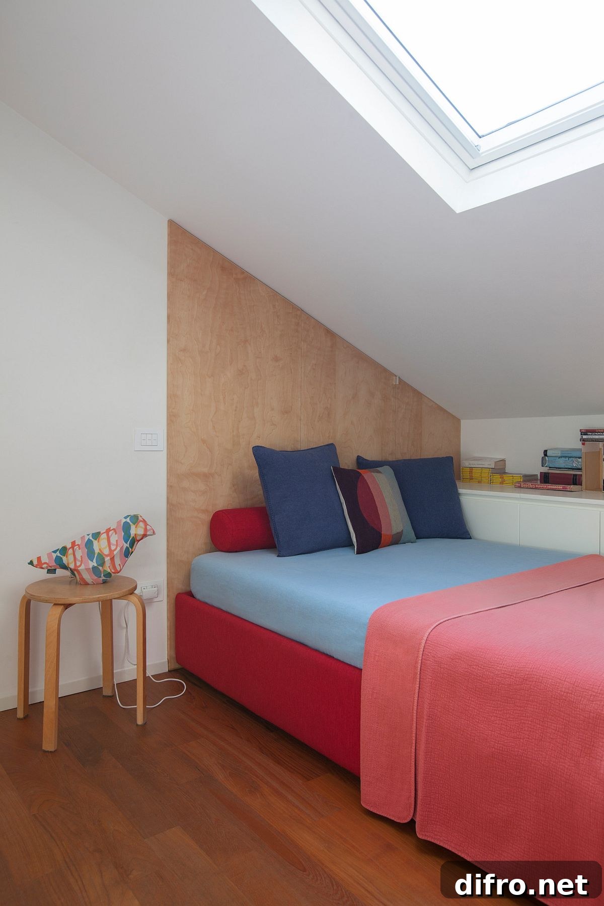 Tiny white and wood bedroom with skylight and bright pink bedding